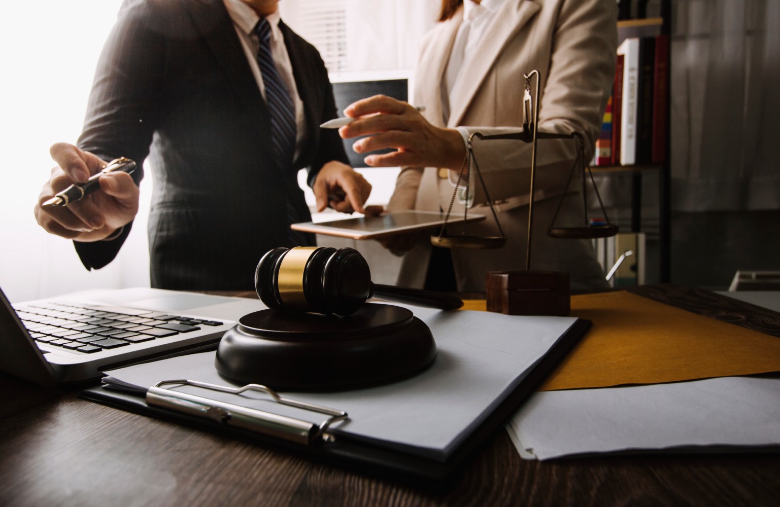 Business and lawyers discussing contract papers with brass scale on desk in office. Law, legal services, advice, justice and law concept picture with film grain effect